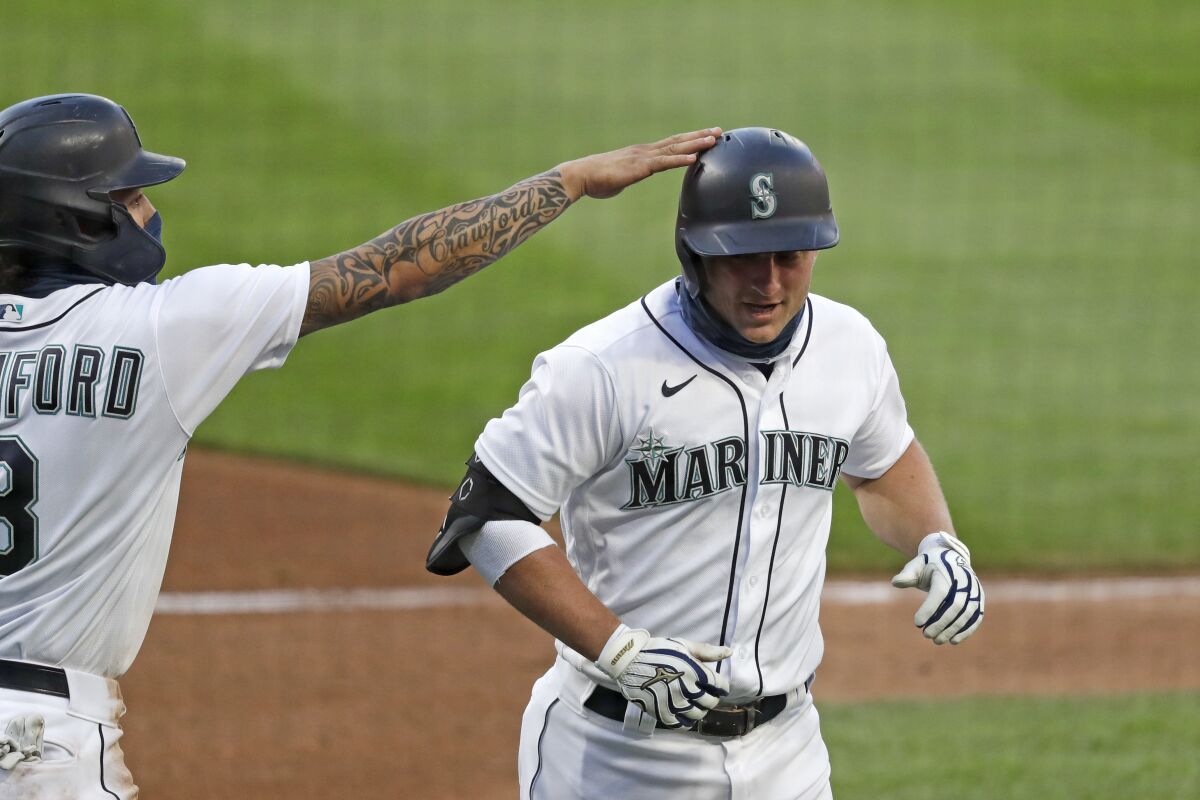 Seattle Mariners' Kyle Seager, right, is congratulated by J.P. Crawford on his three-run home run against the Los Angeles Angels in the third inning of a baseball game Wednesday, Aug. 5, 2020, in Seattle. (AP Photo/Elaine Thompson)