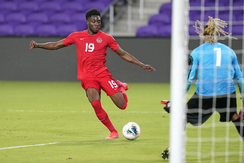 Canada forward Alphonso Davies (19) takes a shot on goal against Bermuda goal keeper Dale Eve (1) during the second half of a World Cup 2022 Group B qualifying soccer match, Thursday, March 25, 2021, in Orlando, Fla. (AP Photo/John Raoux)