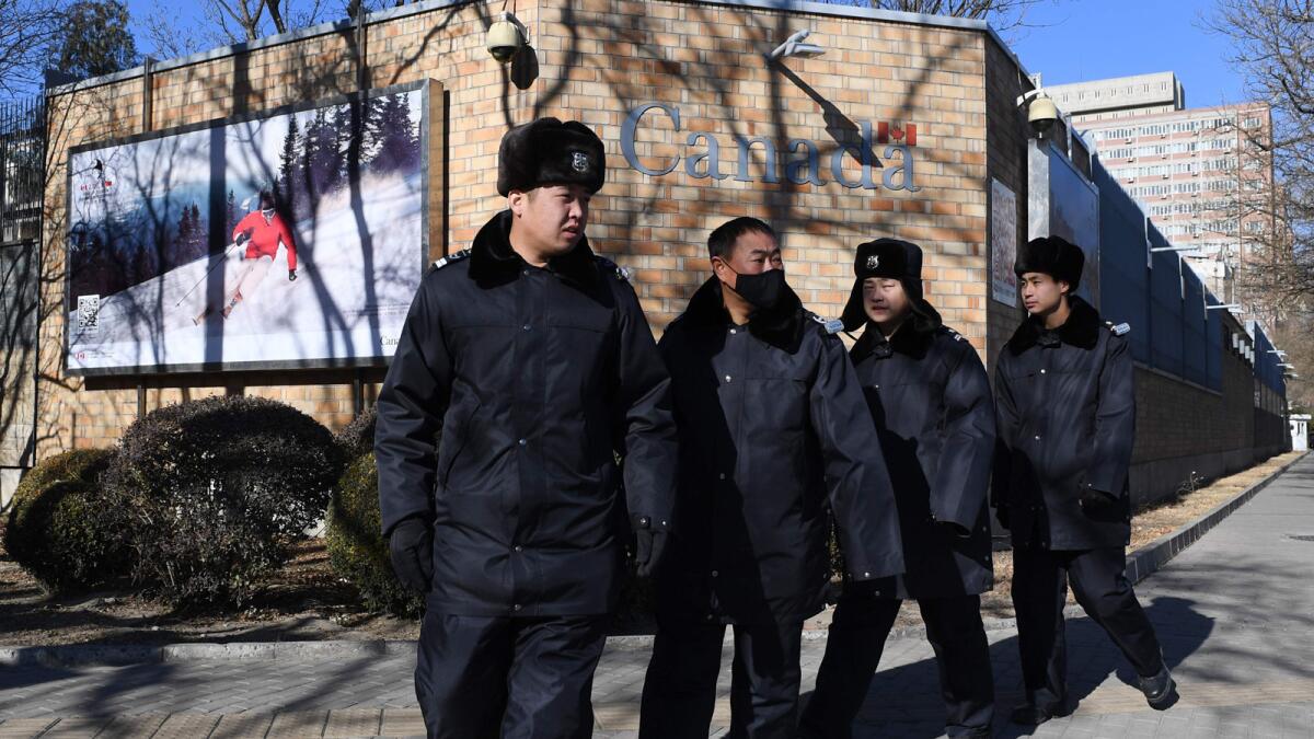 Chinese police patrol Wednesday in front of the Canadian Embassy in Beijing.