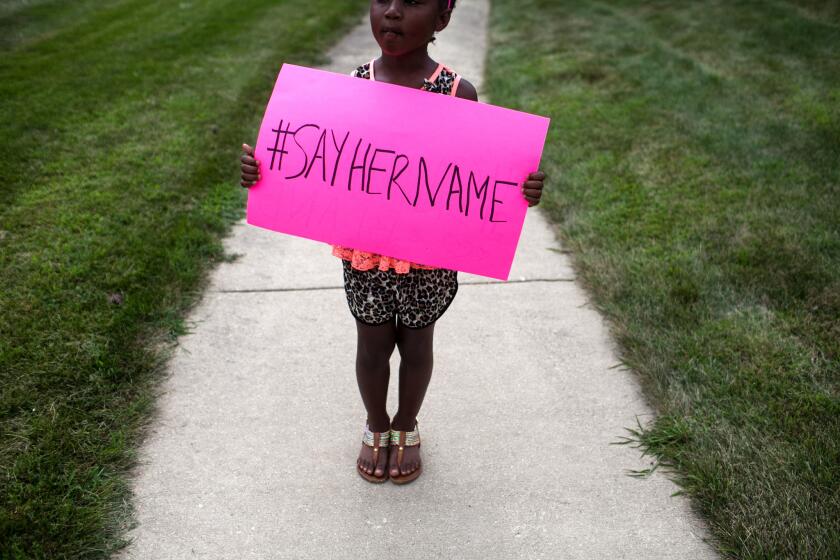 Daija Belcher, 5, holds a sign in front of the DuPage African Methodist Episcopal Church during the funeral service for Sandra Bland on July 25, 2015, in Lisle, Ill. Bland's death roused suspicion nationwide after the 28-year-old was found dead in her jail cell after being pulled over by a Texas state trooper for a traffic violation.