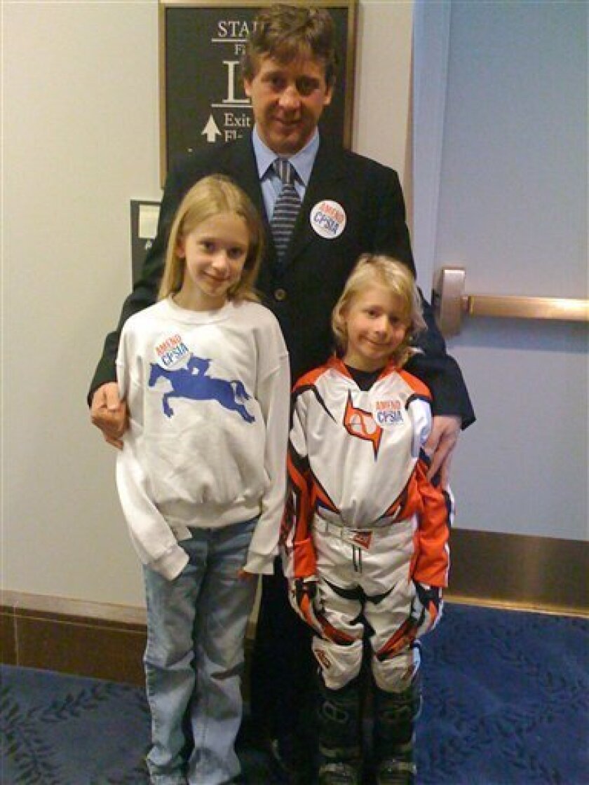 Rodney Yentzer, Carlisle, Pa., poses with his children, nine-year-old Peyton and six-year-old Chase, in Washington Wednesday, April 1, 2009. Motorcycle shops apparently won't get a pass on a new anti-lead law that has kept dirt bikes and ATVs for children off showroom floors. "Please let me have my dirt bike," said 6-year-old Chase Yentzer. "I promise I won't eat my dirt bike." (AP Photo/Jennifer Kerr)