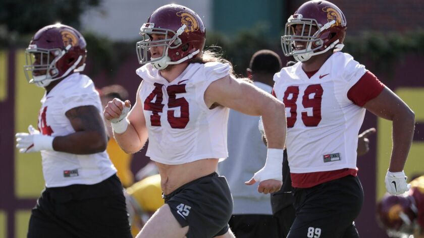 USC linebacker Porter Gustin (45) and defensive lineman Christian Rector (89) run to the workout station during USC football spring practice at Howard Jones Field on Tuesday.