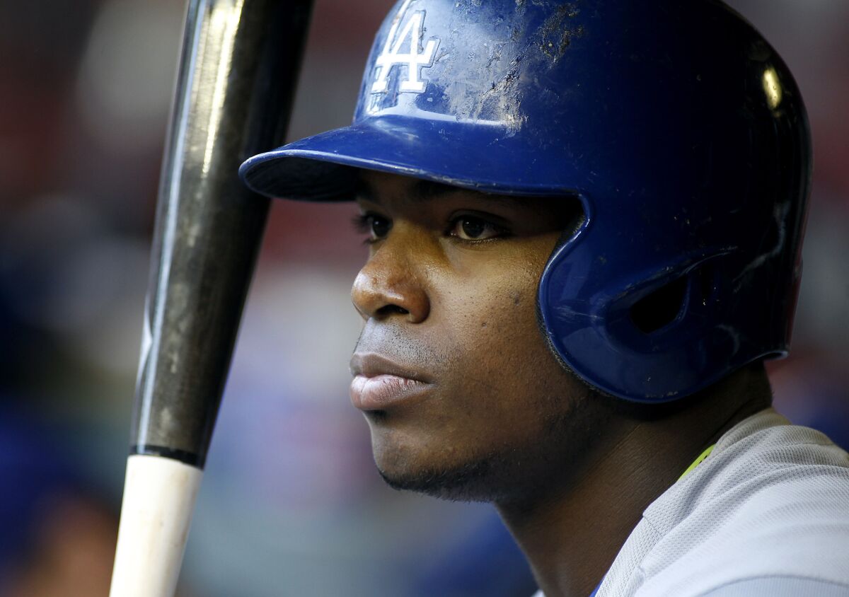Los Angeles Dodgers' Yasiel Puig looks on from the dugout during the first inning of a baseball game against the Arizona Diamondbacks.