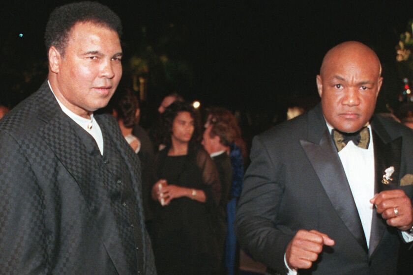 Muhammad Ali, left, and George Foreman arrive at the Vanity Fair Oscar party in Los Angeles on March 24, 1997.