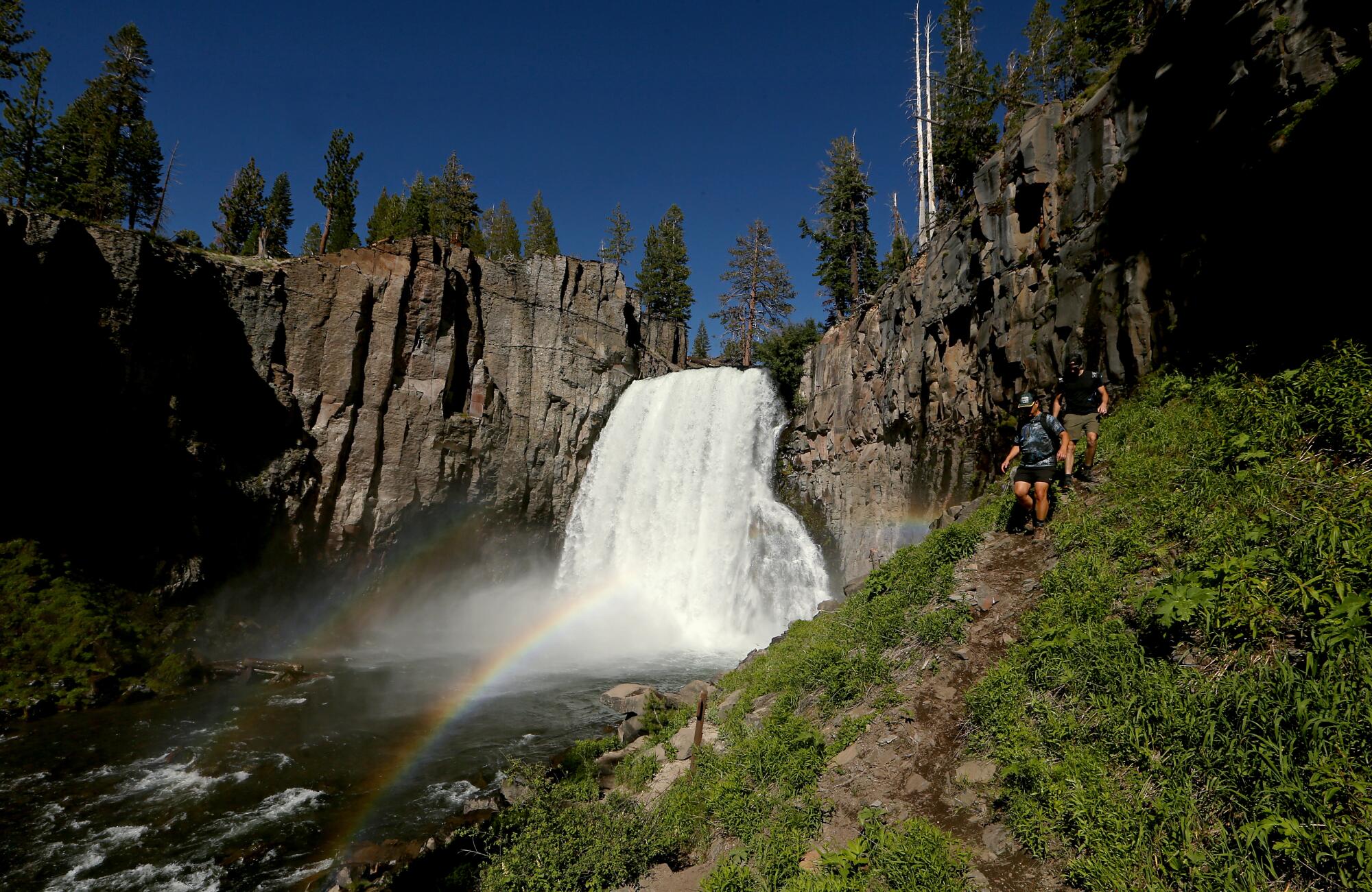 Hikers follow a trail along Rainbow Falls in the Devils Postpile National Monument.
