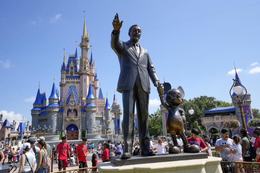 FILE - Guests pass a statue of Walt Disney and Mickey Mouse at the Magic Kingdom at Walt Disney World, July 14, 2023, in Lake Buena Vista, Fla. During the company's annual shareholder meeting Wednesday, April 3, 2024, investors will decide whether to back Disney chief executive Bob Iger, or grant two board seats to activist investor Nelson Peltz and his Trian Partners. (AP Photo/John Raoux, File)