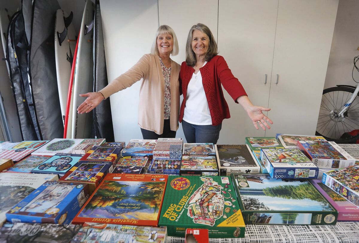 Kristi Edison and Mary Fewel, from left, with puzzles where they offer at a popular monthly puzzle exchange in Costa Mesa.