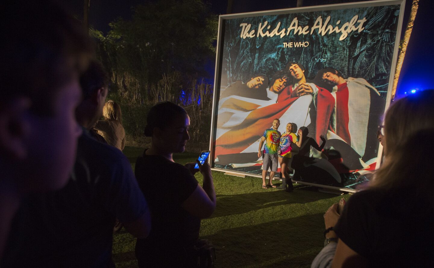 Fans pose for photos with a poster of The Who's "The Kids Are Alright" album.