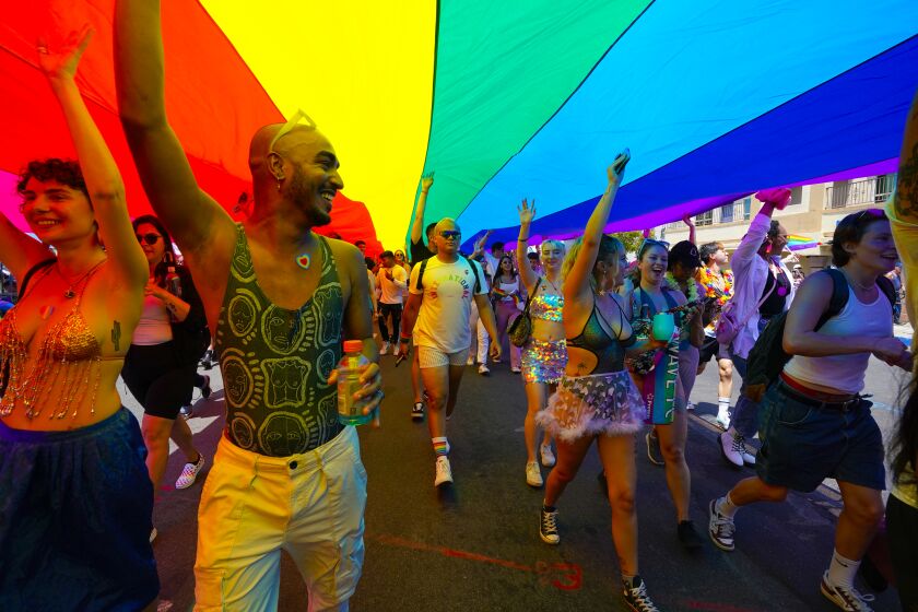 San Diego, CA - July 16: Parade participants march down the parade route on Saturday, July 16, 2022 in San Diego, CA., proudly displaying the Pride flag during San Diego Pride 2022. (Nelvin C. Cepeda / The San Diego Union-Tribune)