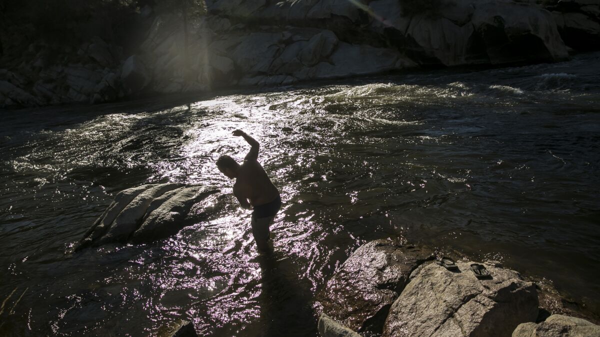 Members of the Gonzalez family soak in the evening sun and play in the cold Kern River.