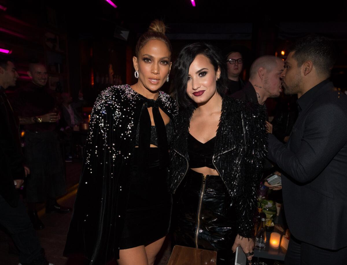 American Music Awards host Jennifer Lopez, left, welcomes Demi Lovato to her after party Sunday night.