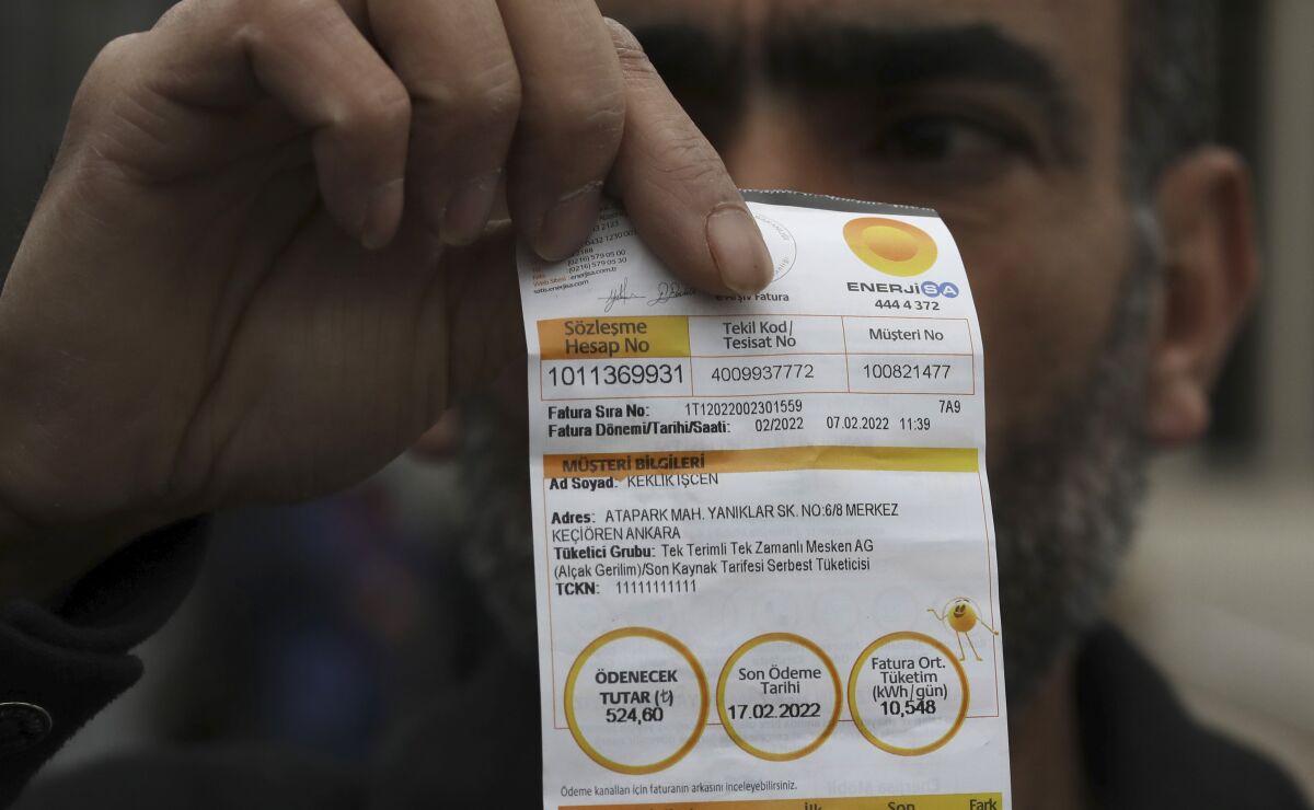 Kazim Iscen, a painter and decorator shows his bill in Ankara, Turkey, Wednesday, Feb. 9, 2022, saying he already has fallen behind on his utility costs and would not be able to pay his electricity bill, which came in "two or three times higher" this month. Spiking energy prices are raising utility bills from Poland to the United Kingdom, leaving people struggling to make ends meet and small businesses uncertain about much longer they can stay afloat. (AP Photo/Burhan Ozbilici)