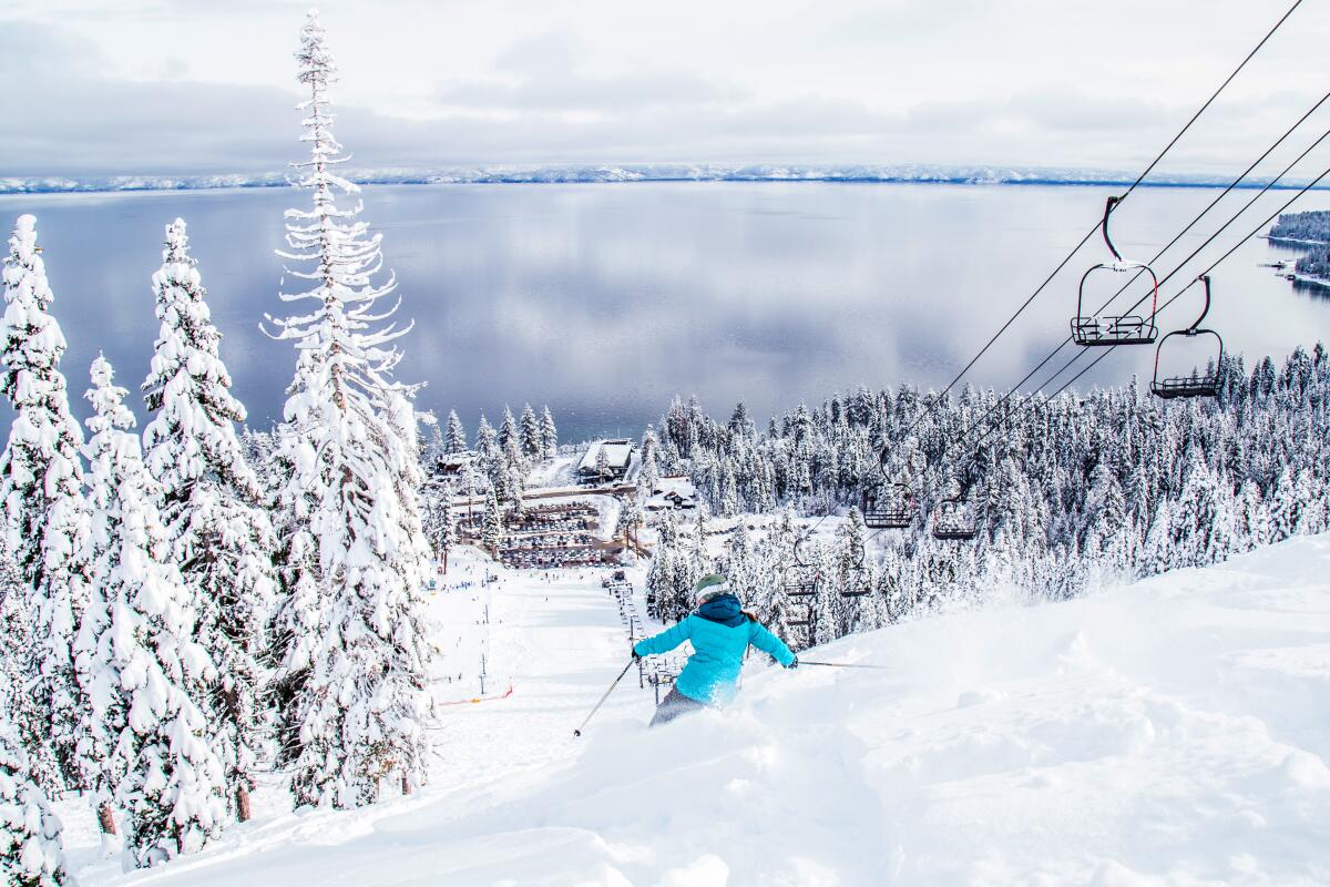 A skier descends a powdery slope at Homewood Mountain Resort with Lake Tahoe below.
