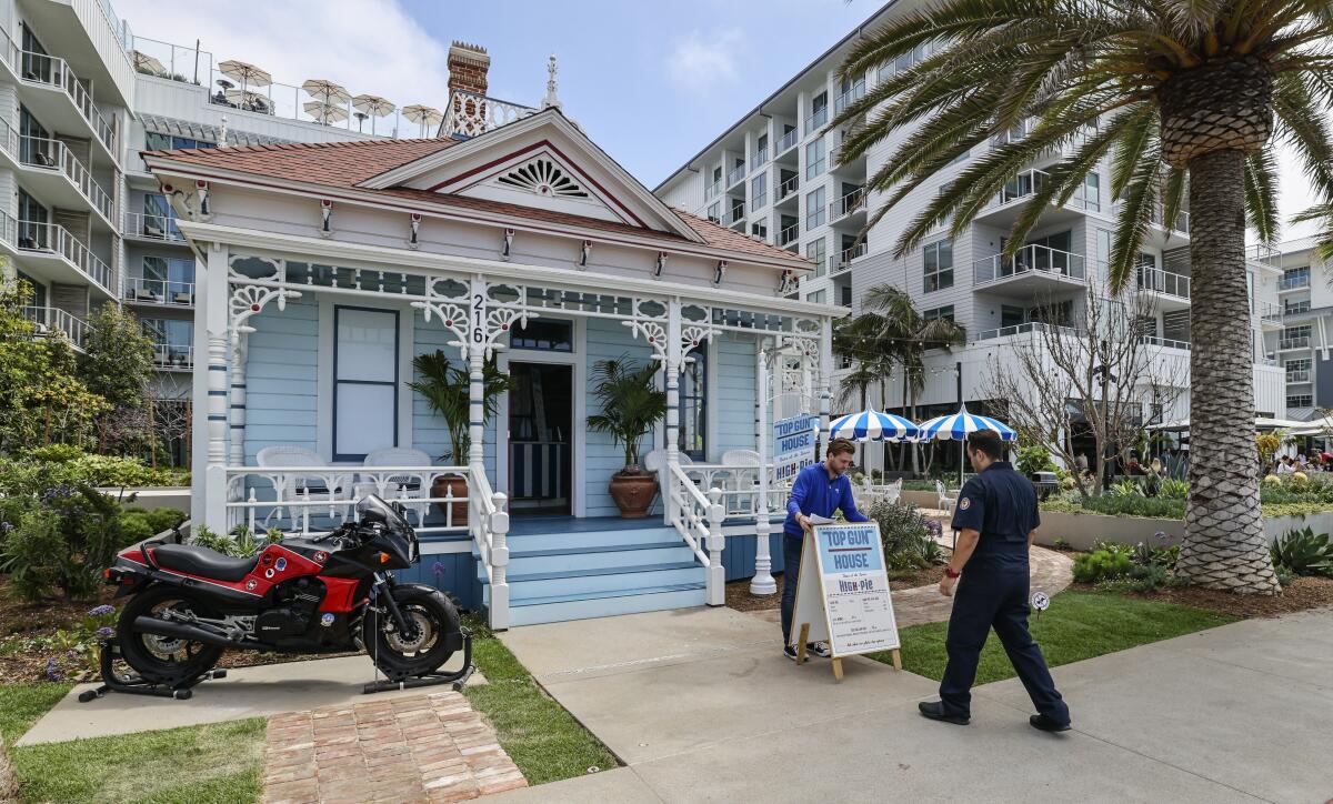 Workers set up a sign outside a Victorian cottage that was featured in "Top Gun."