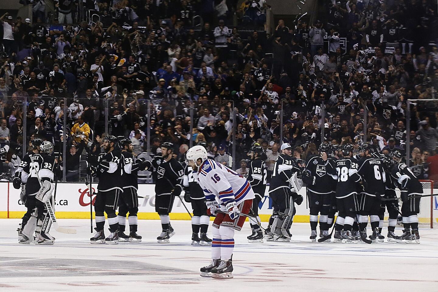 New York Rangers forward Derick Brassard skates off the ice as the Kings and their fans celebrate the team's 3-2 overtime win in Game 1 of the Stanley Cup Final at Staples Center.