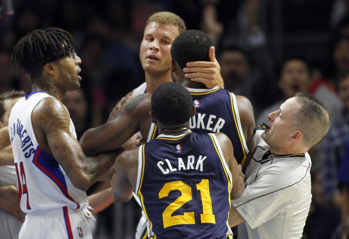 Blake Griffin grabs Utah's Trevor Booker, as Chris Douglas-Roberts, Ian Clark and referee Olandis Poole get involved Oct. 17.