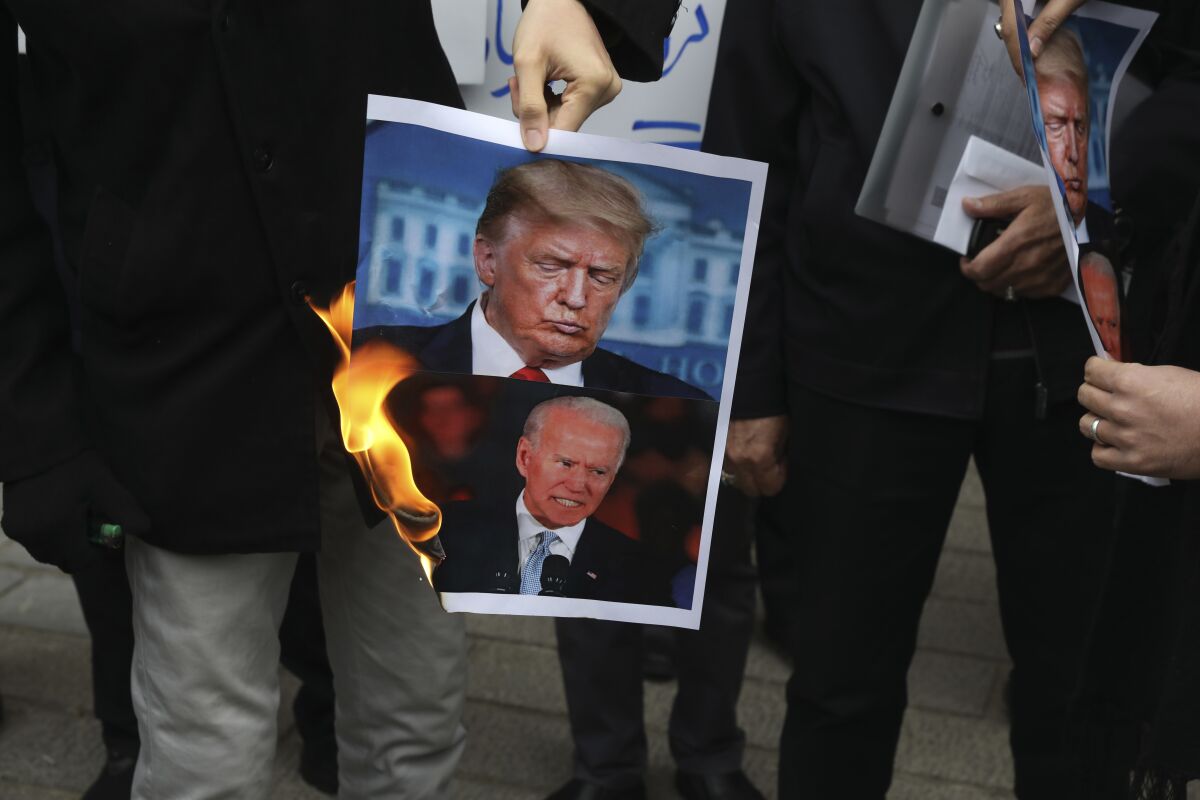 Protesters in Iran burn pictures of President Trump and President-elect Joe Biden on Nov. 28.