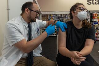 EAGLE ROCK, CA - SEPTEMBER 14: Pharmacist Aaron Sun administers new vaccine COMIRNATY® (COVID-19 Vaccine, mRNA) by Pfizer, to Christine Viveiros at CVS Pharmacy in Eagle Rock, CA. (Irfan Khan / Los Angeles Times)