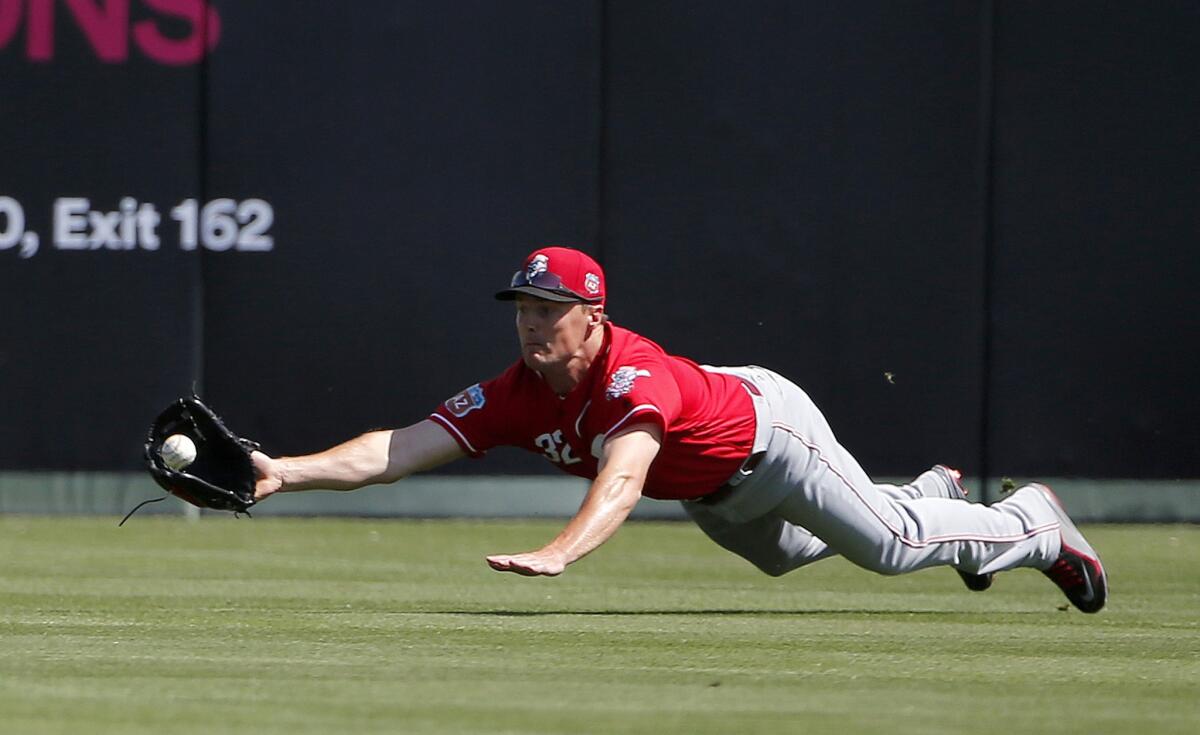 Reds outfielder Jay Bruce dives in vain for a fly ball hit by Angels' Daniel Nava during the first inning.