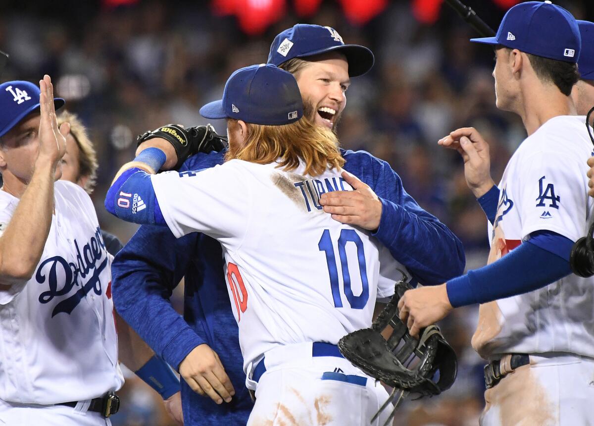 Justin Turner and Clayton Kershaw hug after defeating the Astros in Game 1.