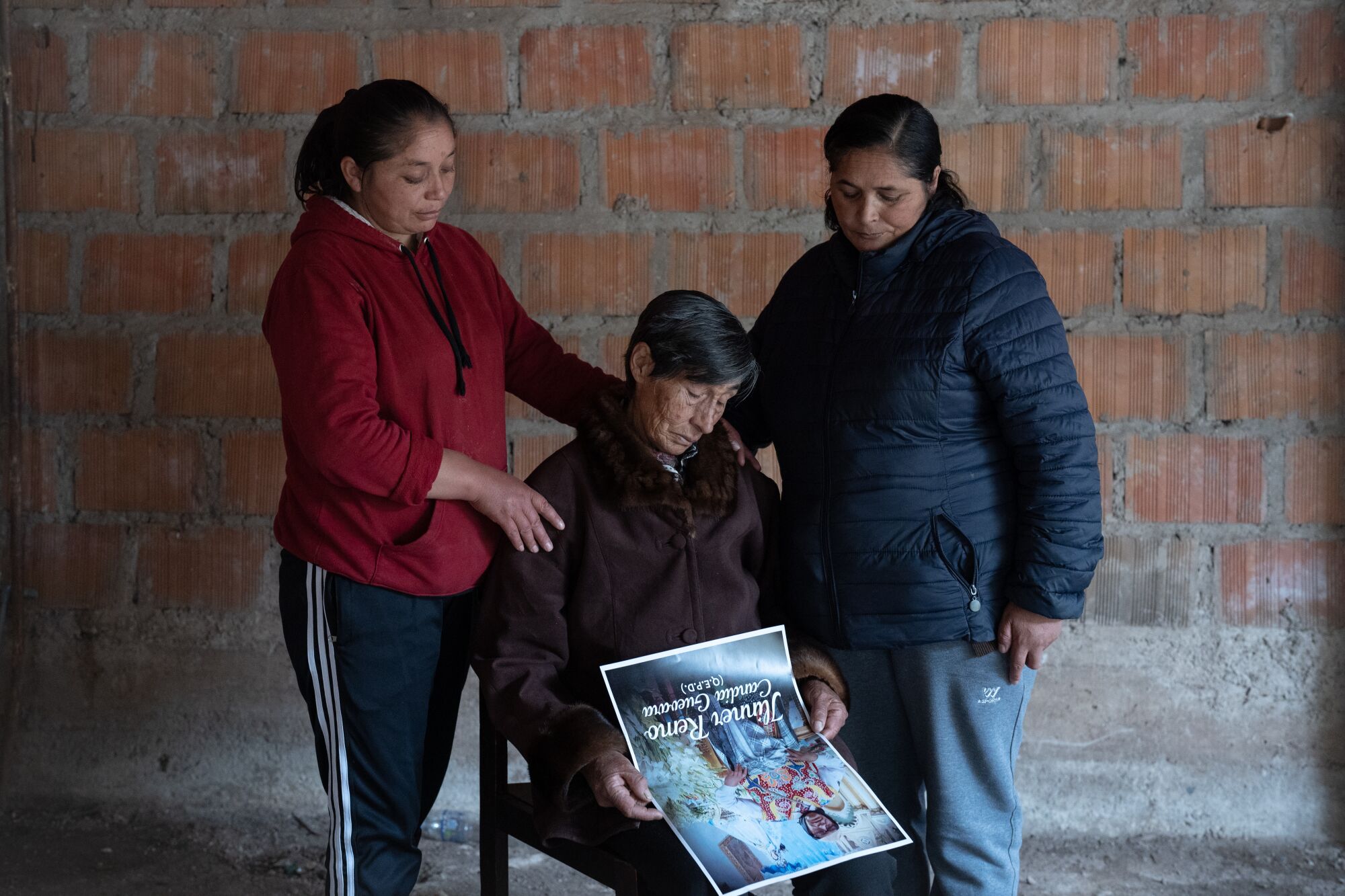 Three women look at a photo.