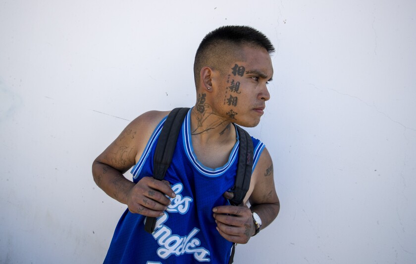 Homeless man Oliver Nguyen stands for a portrait in an alley near Moran Street in the Little Saigon community.