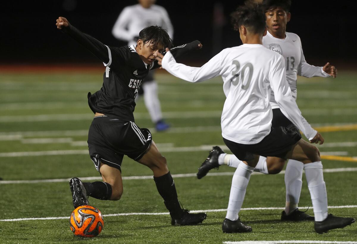 Estancia's Esteban Esquivel, left, battles Century's Yahir Alamzan, center, and Jason Rodriguez for a loose ball during the first half of a nonleague match on Wednesday.