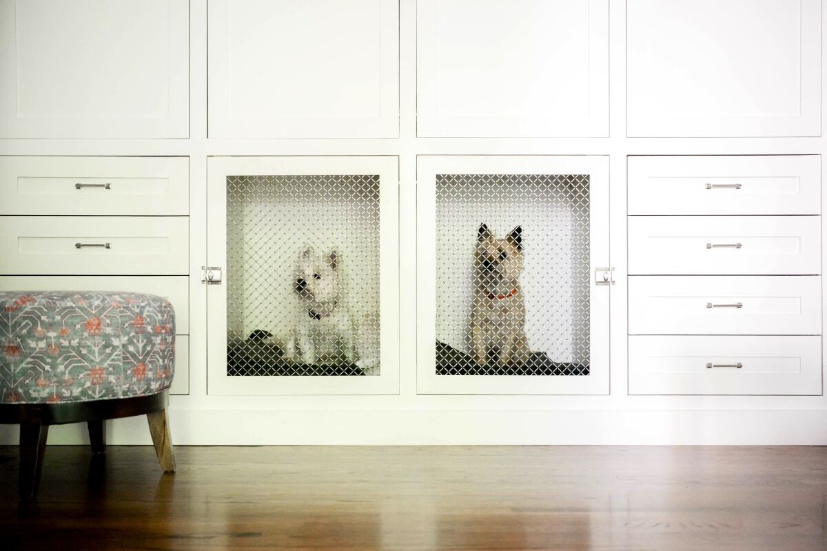 Built-in dog crates in a client’s primary bedroom house two Westies.
