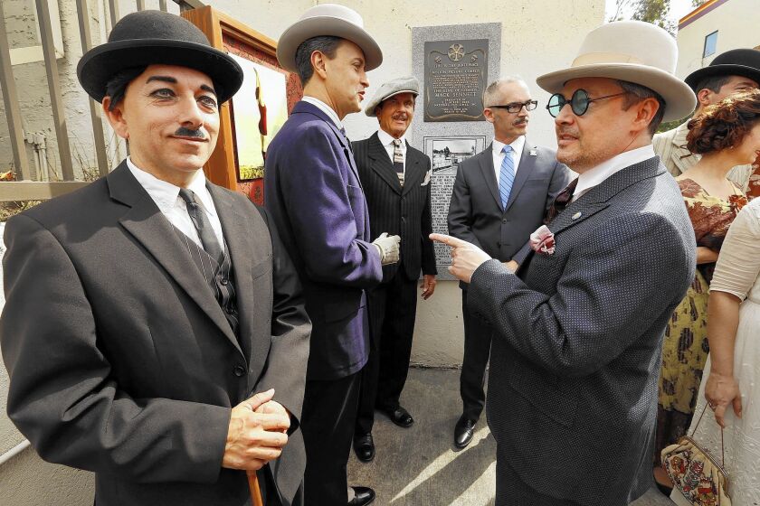 Pharaoh Kingsley, left, playing Charlie Chaplin, joins L.A. City Councilman Mitch O'Farrell, second from right, and others at the unveiling of a new plaque at the site of the old Mack Sennett film studio in what is now Echo Park.