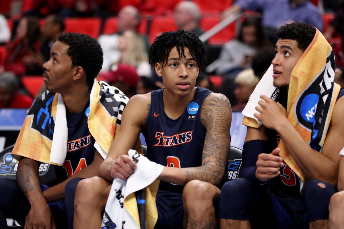 Cal State Fullerton's Khalil Ahmad, left, Kyle Allman and Jackson Rowe react on the bench against Purdue.