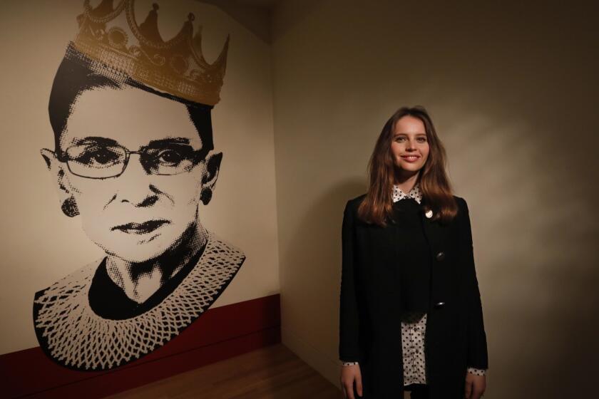 LOS ANGELES, CA - DECEMBER 7, 2018 - - Academy Award nominated actor Felicity Jones poses near an image of Justice Ruth Bader Ginsburg at the exhibit, "Notorious RBG, The Life and Times of Ruth Bader Ginsburg," at the Skirball Cultural Center in Los Angeles on December 7, 2018. Jones plays a younger version of Justice Ginsberg in the film, "On the Basis of Sex." Jones was nominated for the Oscar for the film, "The Theory of Everything." The exhibit, "Notorious RBG, The Life and Times of Ruth Bader Ginsburg," was curated by Cate Thurston and is open until March 10, 2019. (Genaro Molina/Los Angeles Times) ATTENTION EDITOR: THE NAME OF THE EXHIBITION AND LOCATION MUST BE IN THE CAPTION. THIS IS WHAT KEN KWOK AND PR AT THE SKIRBALL AGREED TOO.