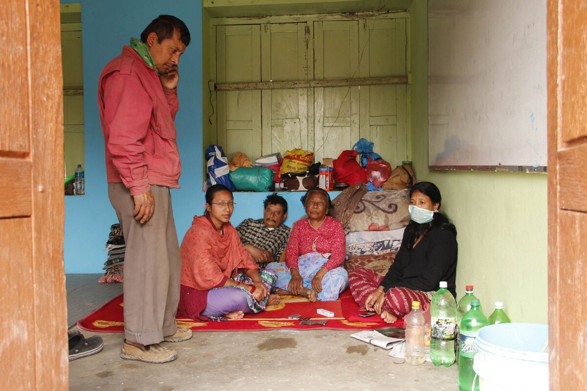 Nem Tamrakar, left, and his family take refuge Friday in a school classroom in Bhaktapur, Nepal.