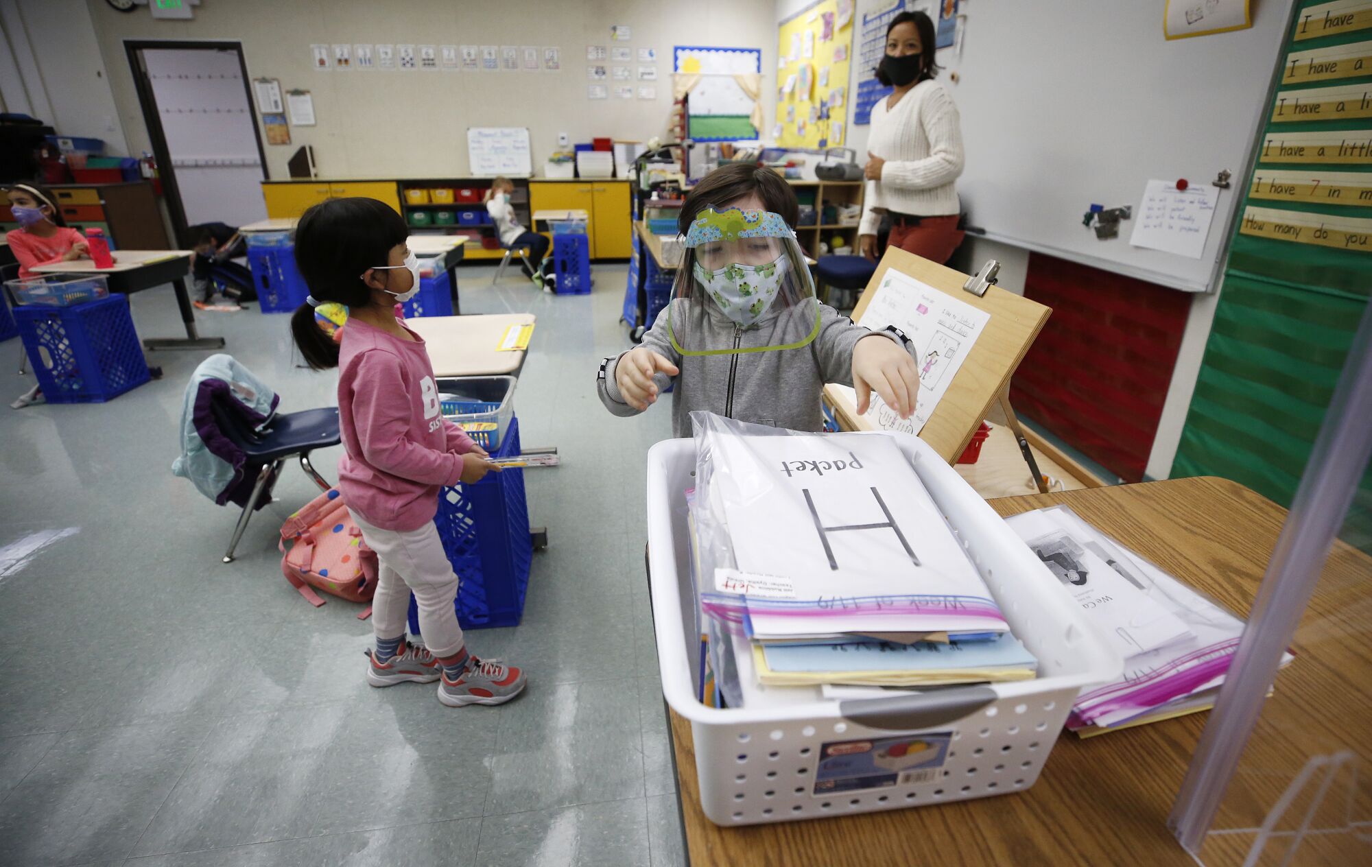 Kindergarten teacher Ursula Dysthe watches as students submit homework at Lupin Hill Elementary.