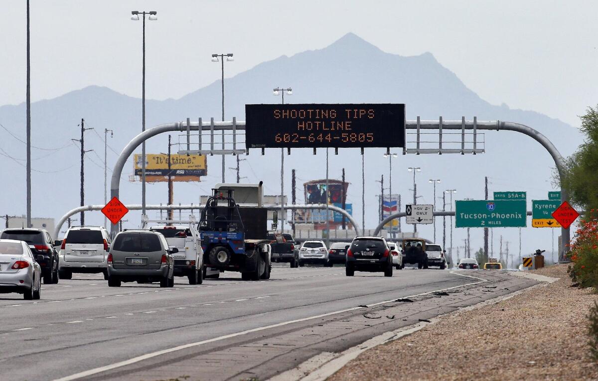 An Arizona Department of Transportation sign gives a hotline number for information on the recent freeway shootings on I-10 in Chandler, Ariz.