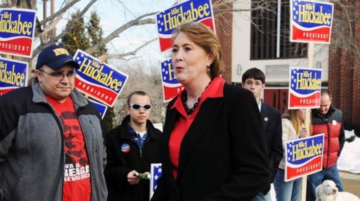 Janet Huckabee, wife of presidential candidate Mike Huckabee, speaks with voters at the Methodist Episcopalian Church polling station in Dover, N.H. She met the former Arkansas governor when both were in junior high school in Hope, Ark.