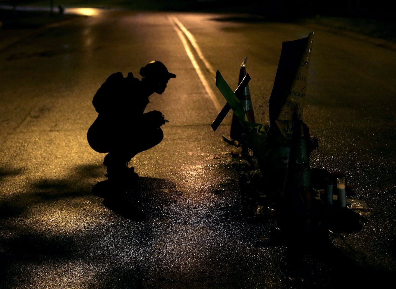 Ty Crustfield pauses Aug. 15 before a makeshift memorial in the middle of the street where Michael Brown was killed by police in Ferguson, Mo.