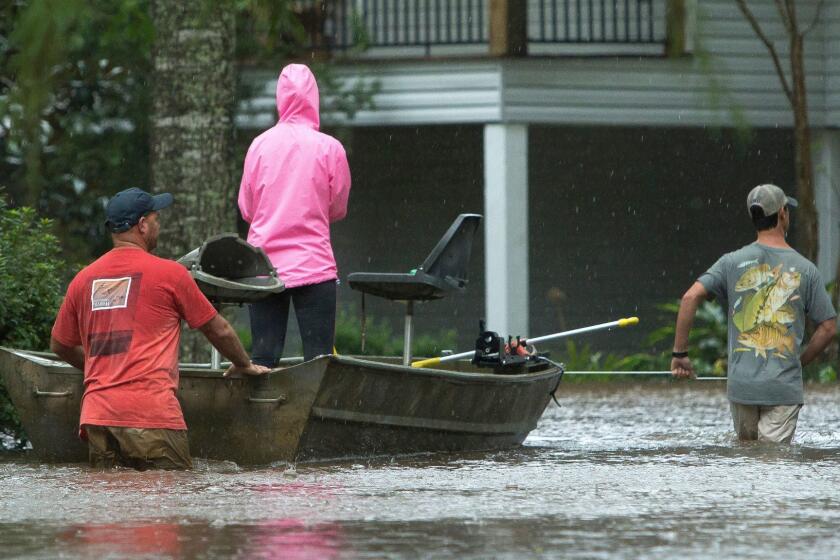 Residents of Cypress Lake Dr. use boats to transport others and retrieve items from flooded homes in Moss Bluff, La., Tuesday, Aug. 29, 2017. (Rick Hickman/American Press via AP)