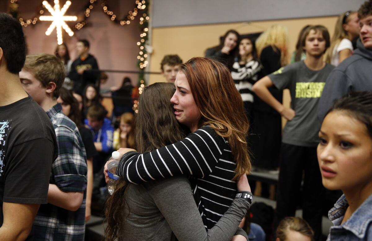 Freshman Allie Zadrow, center right, hugs classmate Liz Reinhardt at a church after a shooting at nearby Arapahoe High School in Centennial, Colo. Students from the school were evacuated to the church.