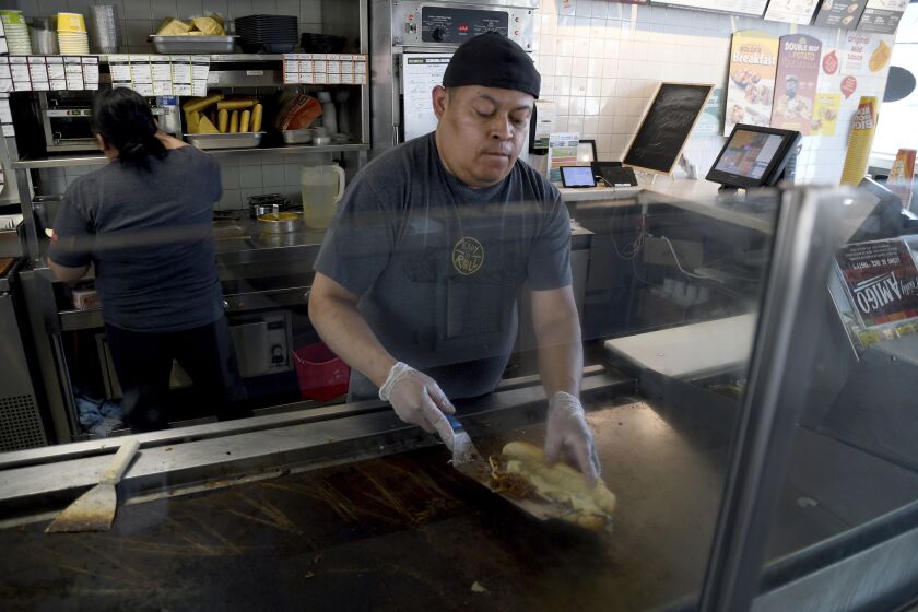 Ricardo Acosta prepares food at a Taco John's restaurant in Denver on Tuesday, May 16, 2023. Taco Bell is asking U.S. regulators to force Wyoming-based Taco John's to abandon its longstanding claim to the "Taco Tuesday" trademark. (AP Photo/Thomas Peipert)
