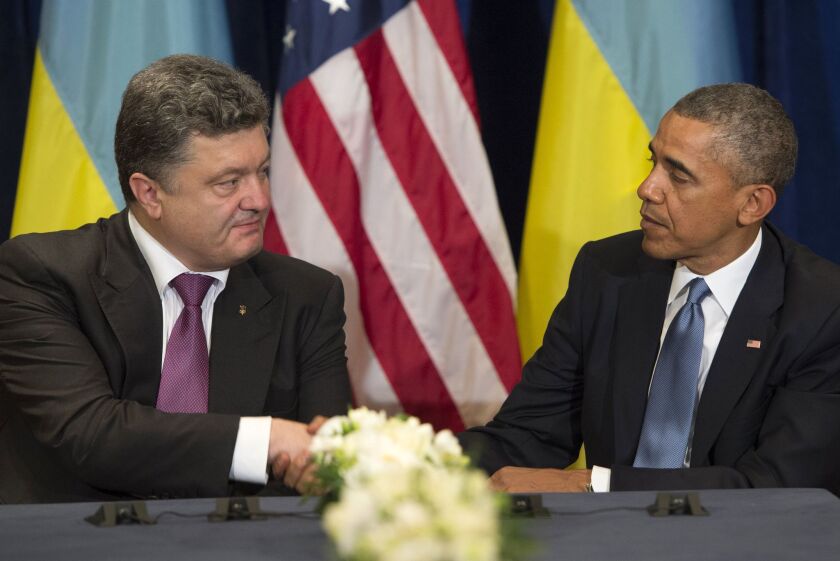 President Obama and Ukrainian President-elect Petro Poroshenko shake hands during a meeting in Warsaw.