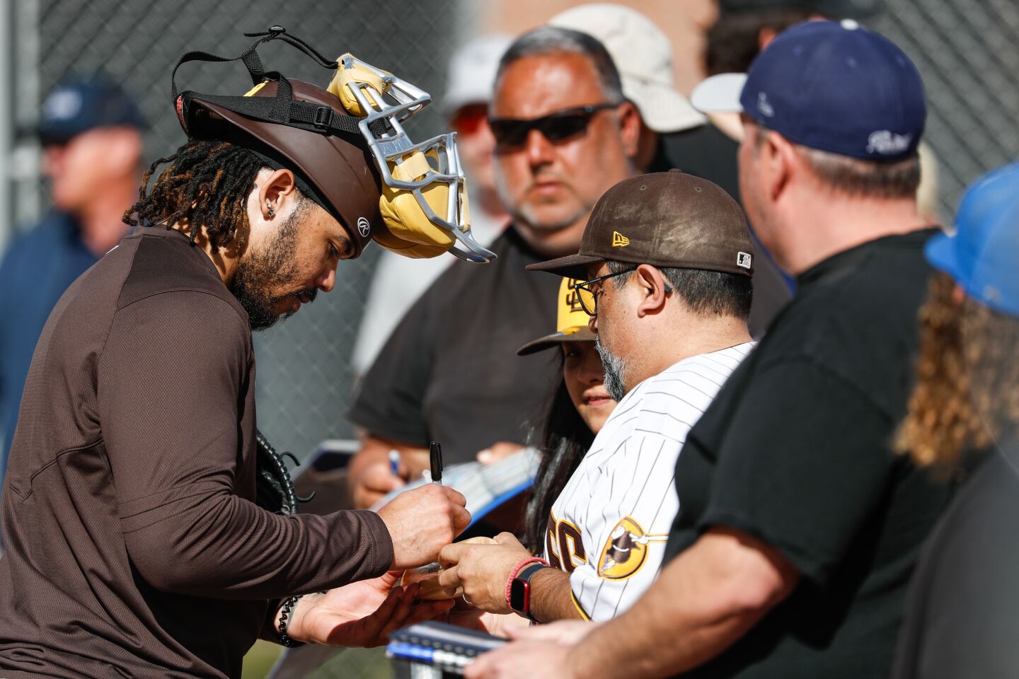 Padres catcher Luis Campusano (12) signs autographs for fans during a spring training practice at the Peoria Sports Complex on Sunday, Feb. 19, 2023 in Peoria, AZ.