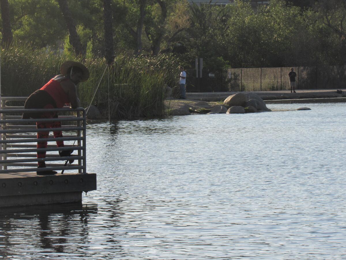 Delilah Davis of Paradise Hills waits for a bite of catfish at Santee Lakes on a recent evening.