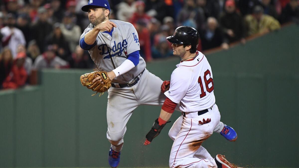 Dodgers second baseman Brian Dozier throws to first as Boston Red Sox's Andrew Benintendi slides in the third inning of Game 1 of the World Series at Fenway Park. Benintendi was out on the play.