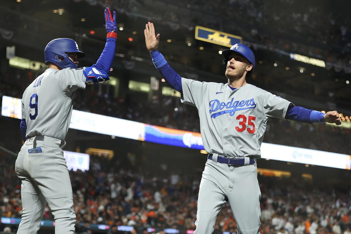 Cody Bellinger is congratulated by Gavin Lux after scoring during the sixth inning of Game 2.