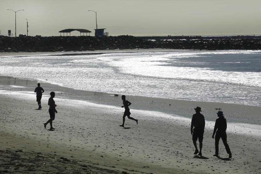 People walk and run on a beach