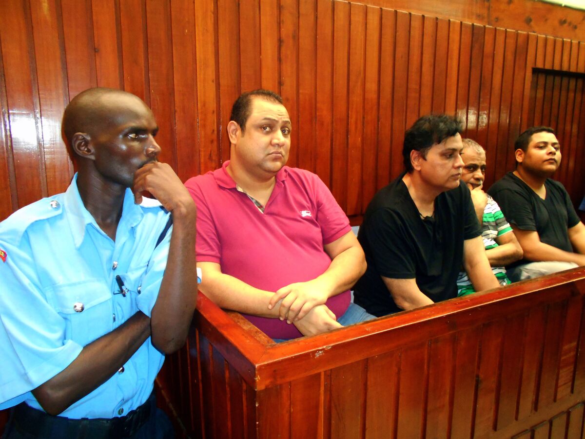 Baktash Akasha Abdalla (in red shirt) appears in Mombasa Law Courts in Kenya on Feb. 9, 2015, for a bond hearing, along with co-defendants (from third left) Vijaygiri "Vicky" Anandgiri, Gulam Hussein, and brother Ibrahim Akasha Abdalla. The four were arrested in November 2014 after the U.S. issued an Interpol "red notice" for their capture and request for extradition.