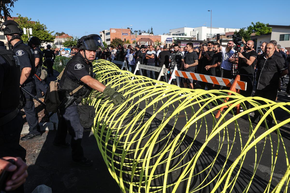 Glendale Police stretch out razor wire to separate a growing group of protesters 