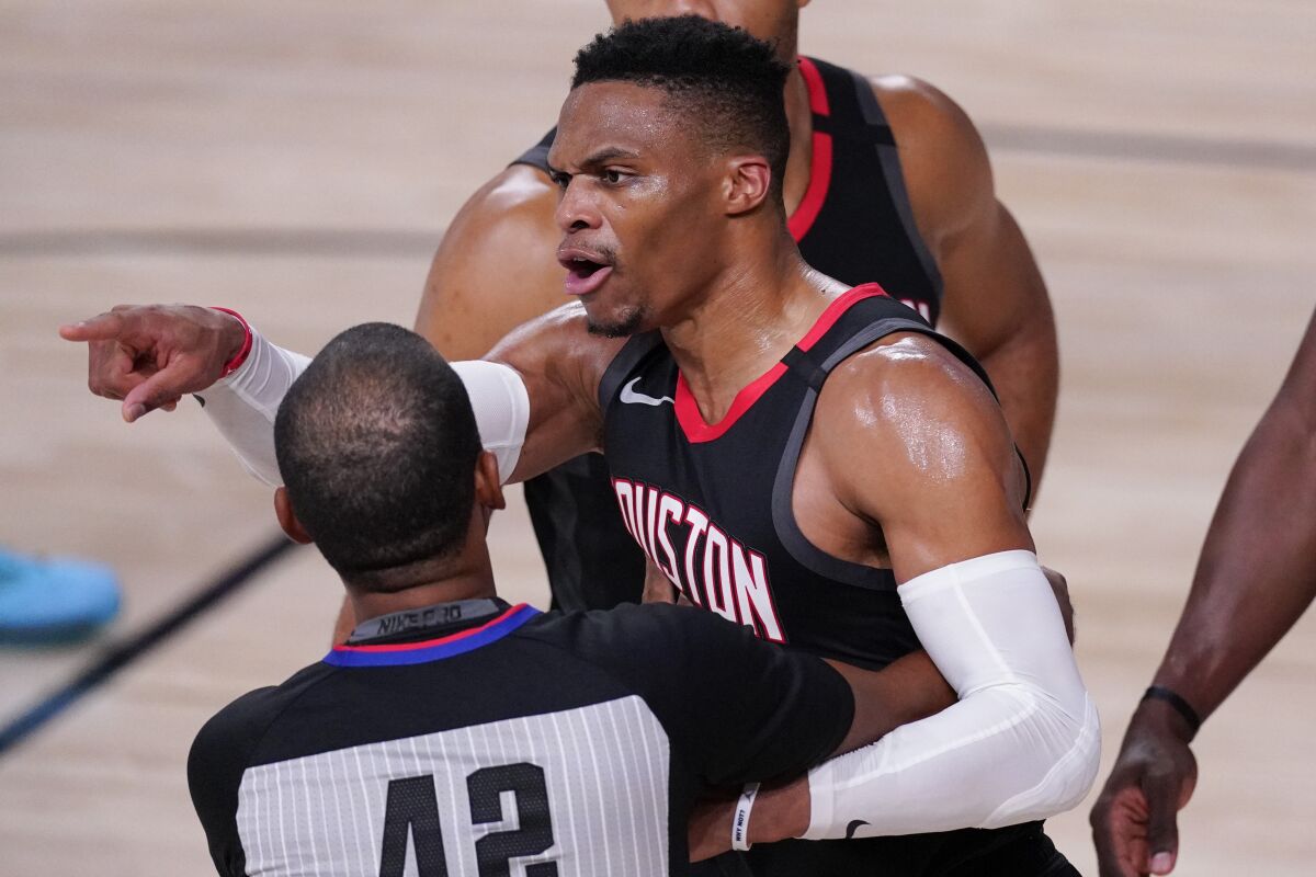 The Rockets' Russell Westbrook is held back by a referee as he argues during the second half Saturday.