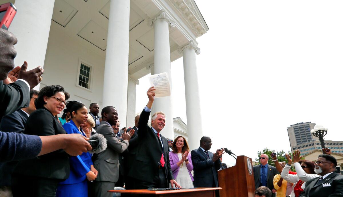 Gov. Terry McAuliffe holds up the order he signed to restore rights to felons in Virginia at the Capitol in Richmond, Va. on April 22, 2016.