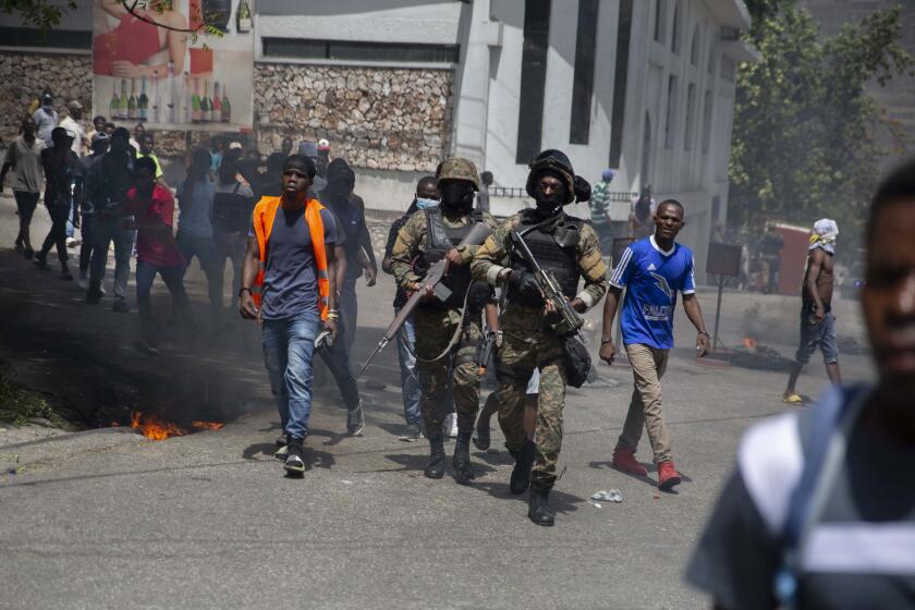 Police walk among protesters during a protest against the assassination of Haitian President Jovenel Moïse near the police station of Petion Ville in Port-au-Prince, Haiti, Thursday, July 8, 2021. Officials pledged to find all those responsible for the pre-dawn raid on Moïse’s home early Wednesday in which the president was shot to death and his wife, Martine, critically wounded. (AP Photo/Joseph Odelyn)